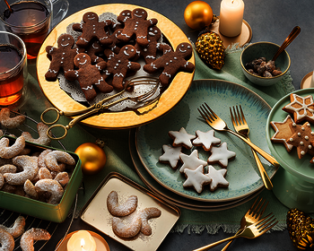 Bild mit verschiedenen gebackenen Keksen aus Wewalka Keksteigen, angerichtet auf Platten und Tellern mit weihnachtlicher Deko, darunter Honiglebkuchen, Zimtsterne und Vanillekipferl