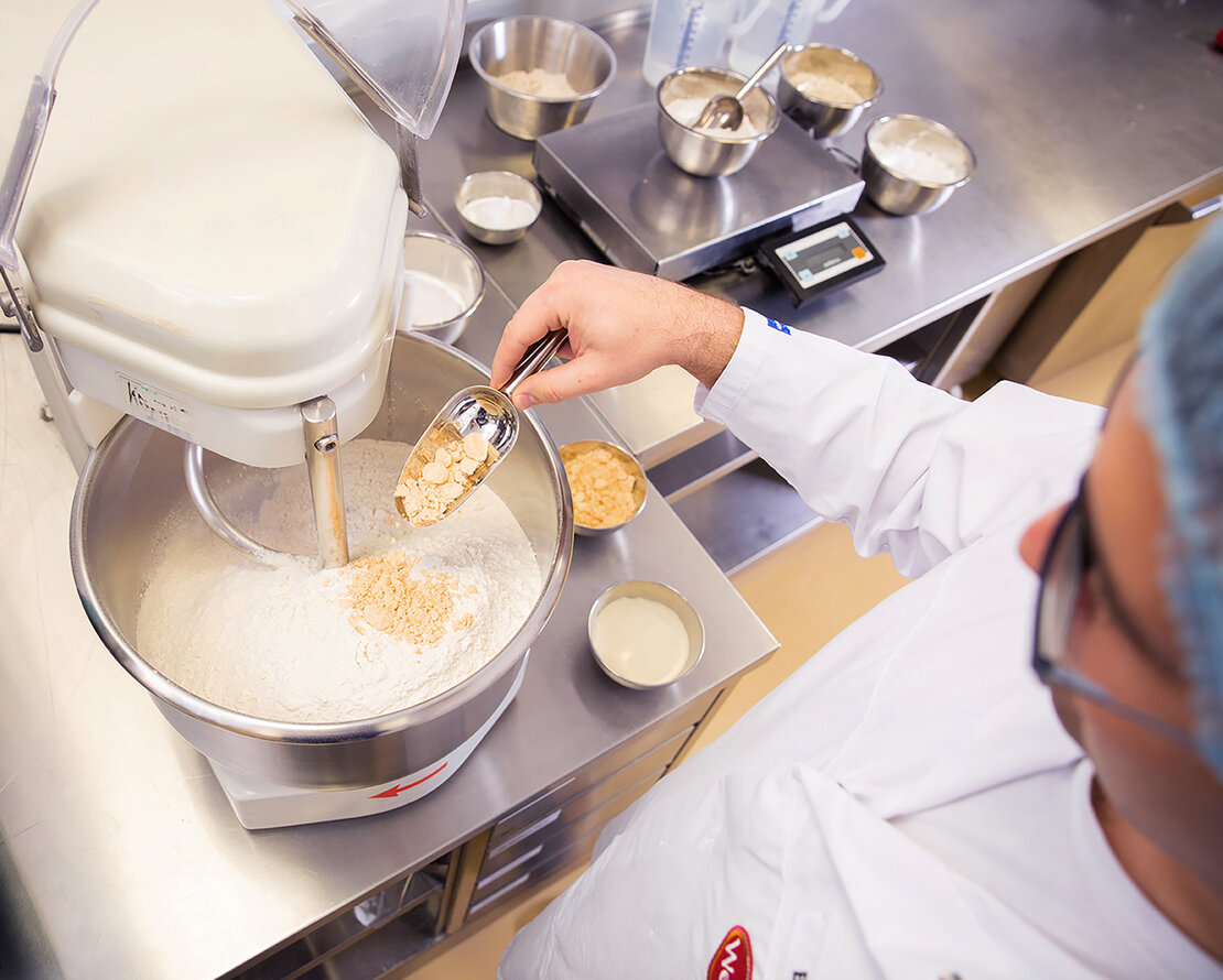 Picture of an employee of Wewalka, mixing a dough and with thus developing a new fresh dough recipe
