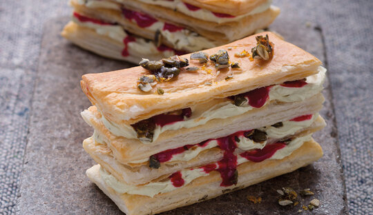 Picture of a puff pastry-lasagna, prepared of Wewalka puff pastry-dough, filled with a cream and berries, presented on a wooden board